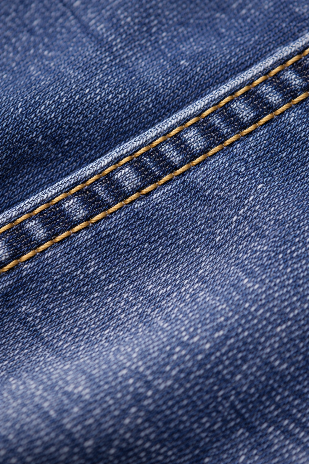 sps-kids-denim-jeans-fabric-texture Close-up of blue denim fabric with a visible seam.